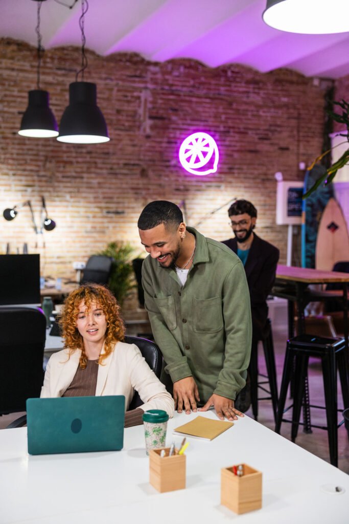 Three team members at eCommerce App Review collaborating in a modern workspace, reviewing Shopify and WooCommerce app content.