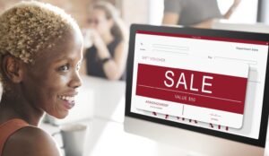 A woman gazes at a sale sign displayed on her computer screen in a popup ecommerce window.